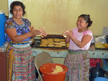 ladies in the kitchen, making tortillas for the 
lunch