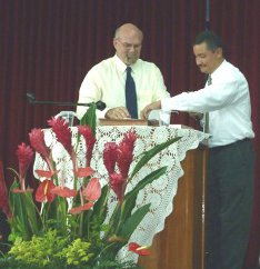 Larry Crabtree and Cesar Rodriquez 
speaking together in a Church